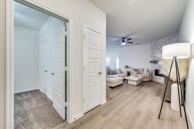 living room with ceiling fan and light hardwood / wood-style flooring