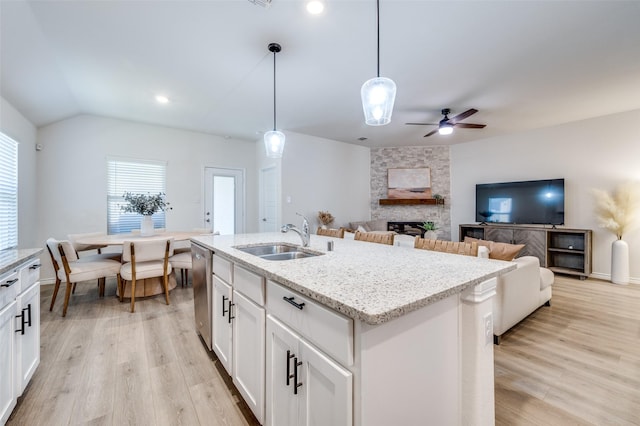 kitchen featuring a center island with sink, white cabinetry, hanging light fixtures, and sink