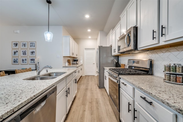 kitchen featuring appliances with stainless steel finishes, white cabinets, and sink