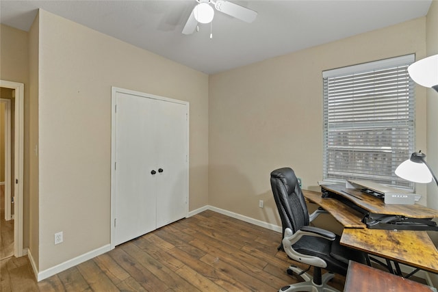 home office with ceiling fan and dark hardwood / wood-style flooring