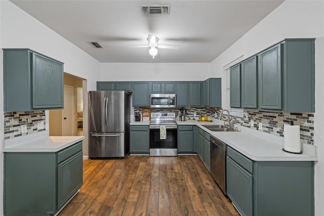 kitchen featuring sink, ceiling fan, decorative backsplash, dark hardwood / wood-style floors, and appliances with stainless steel finishes