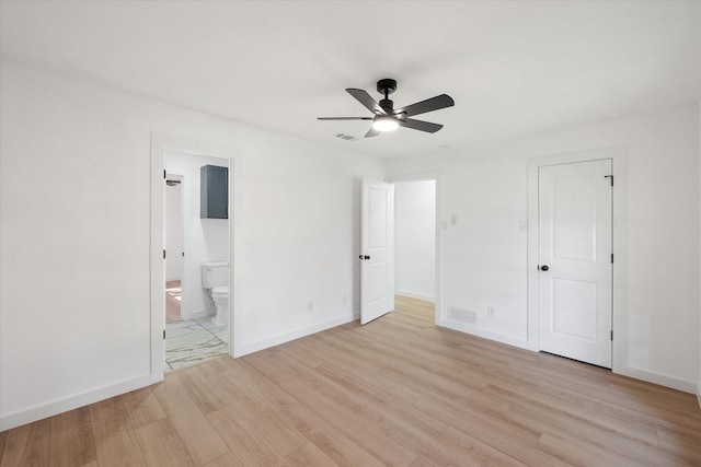 unfurnished bedroom featuring light wood-type flooring, ceiling fan, a closet, and connected bathroom