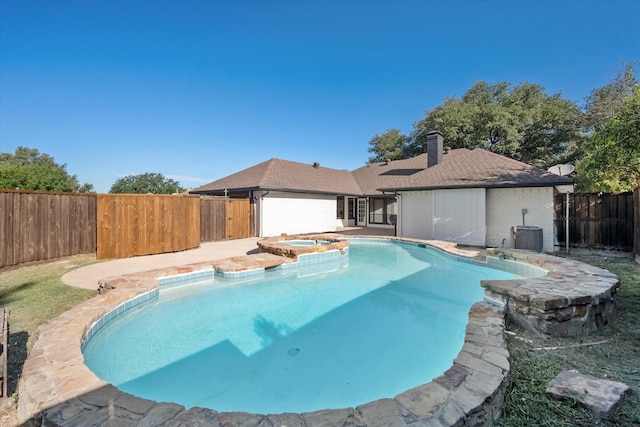 view of pool featuring central AC unit and an in ground hot tub