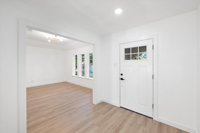 entrance foyer featuring a notable chandelier and light hardwood / wood-style flooring