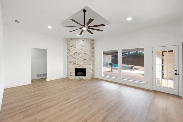 unfurnished living room featuring a fireplace, ceiling fan, and light wood-type flooring