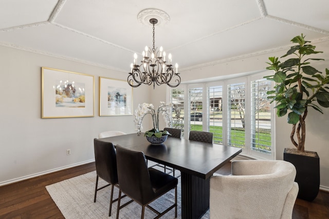 dining space with dark hardwood / wood-style flooring, an inviting chandelier, and crown molding