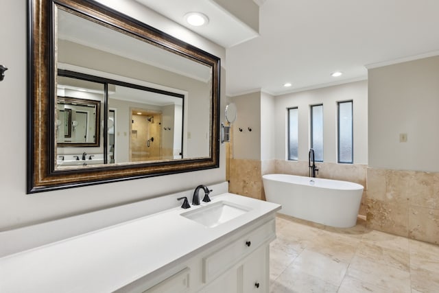 bathroom with ornamental molding, independent shower and bath, tile walls, and vanity