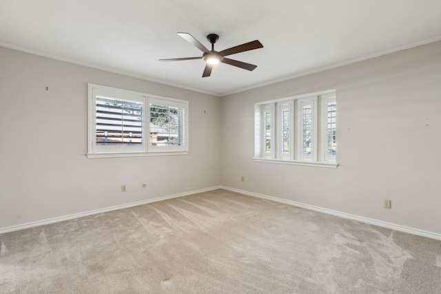 empty room featuring ceiling fan, light colored carpet, and ornamental molding