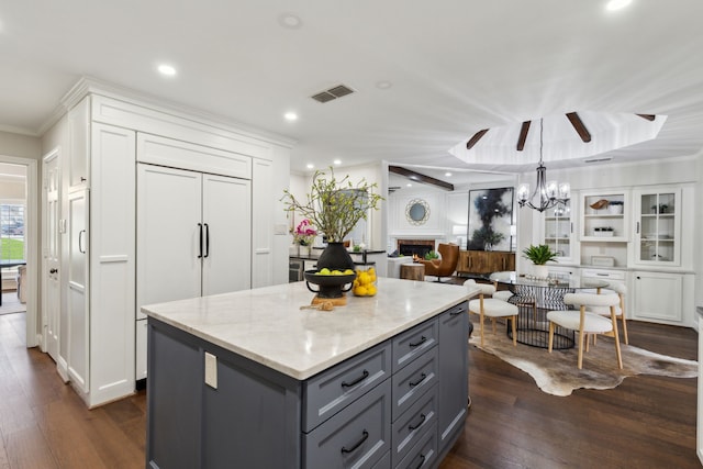 kitchen with white cabinets, light stone counters, and dark hardwood / wood-style floors