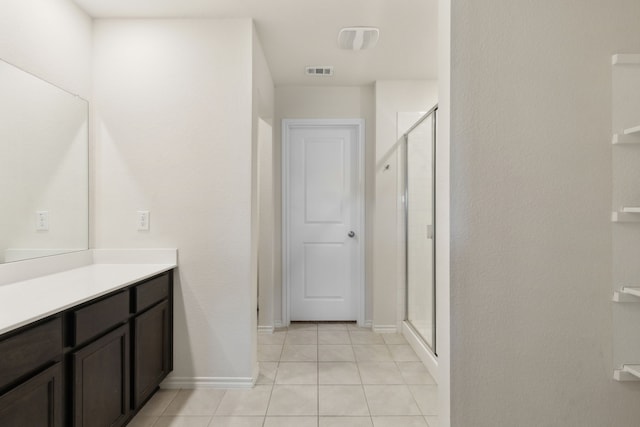 bathroom with walk in shower, tile patterned flooring, and vanity