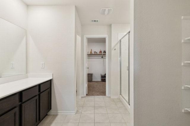 bathroom with tile patterned flooring, an enclosed shower, and vanity