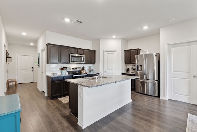 kitchen featuring stainless steel appliances, a kitchen island with sink, dark hardwood / wood-style flooring, dark brown cabinets, and sink