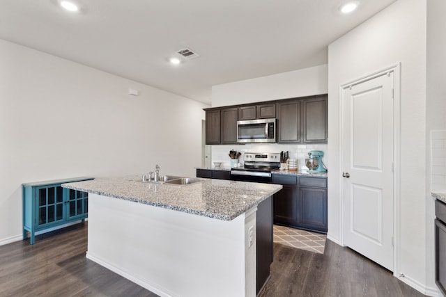 kitchen featuring sink, stainless steel appliances, dark brown cabinets, and a kitchen island with sink