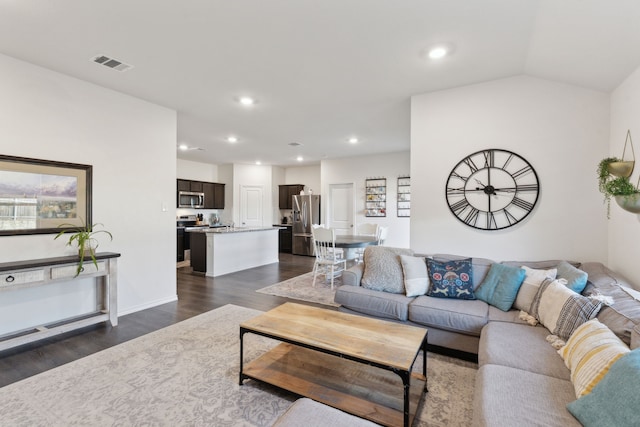 living room featuring dark wood-type flooring and lofted ceiling