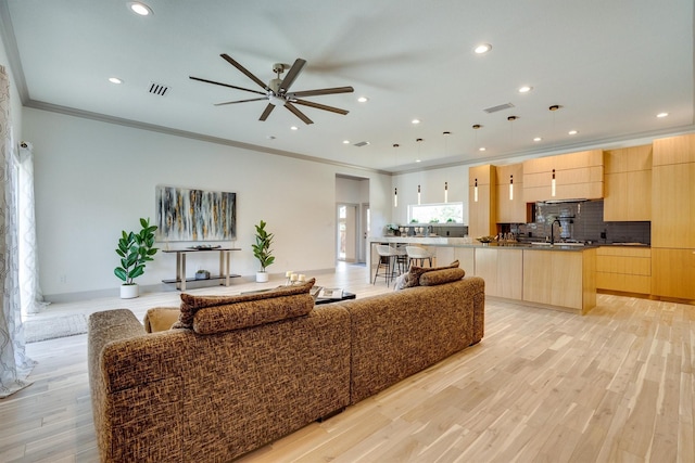 living room with sink, ceiling fan, light hardwood / wood-style floors, and ornamental molding