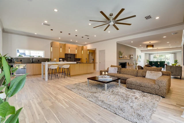 living room featuring ornamental molding, ceiling fan, light hardwood / wood-style floors, and wine cooler