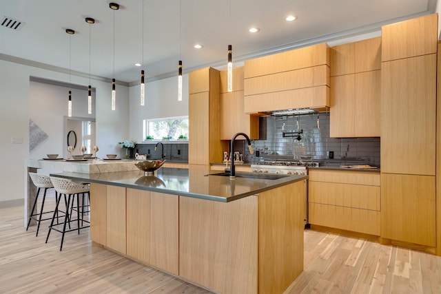 kitchen with pendant lighting, light brown cabinetry, a large island, crown molding, and sink