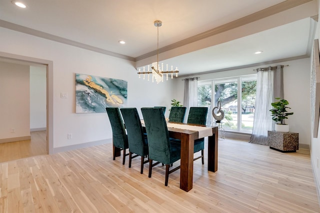 dining room with a chandelier, ornamental molding, and light wood-type flooring