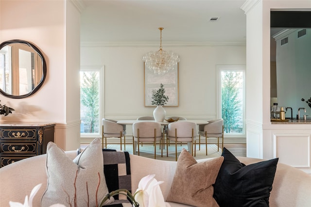 dining area featuring an inviting chandelier, ornamental molding, and sink