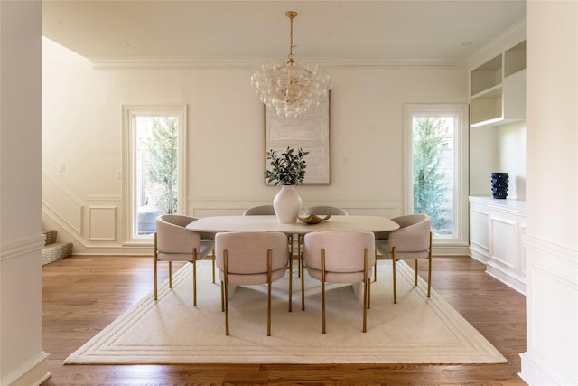 dining room featuring hardwood / wood-style flooring, an inviting chandelier, ornamental molding, and a wealth of natural light