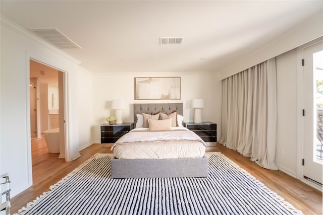 bedroom featuring ornamental molding and light hardwood / wood-style flooring