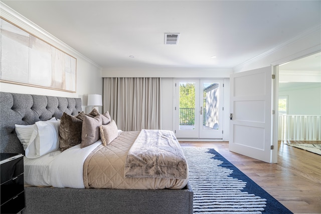 bedroom featuring french doors, ornamental molding, wood-type flooring, and access to exterior