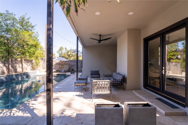 view of patio / terrace with an outdoor living space, ceiling fan, and a fenced in pool