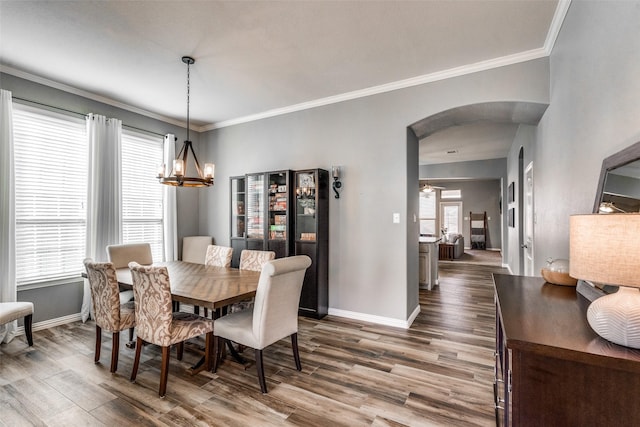 dining space with a notable chandelier, hardwood / wood-style floors, and crown molding