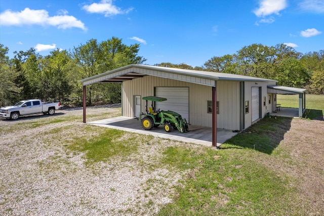 view of outbuilding featuring a garage, a carport, and a lawn