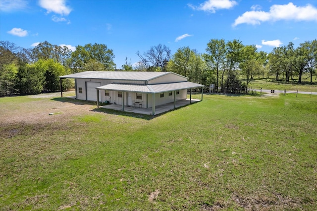 back of house with a yard, covered porch, and a garage