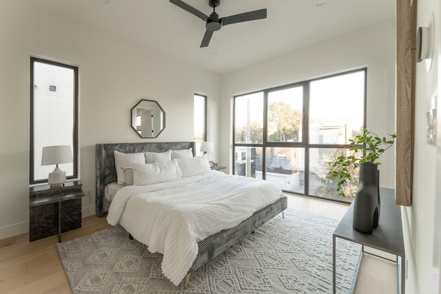 bedroom featuring access to outside, ceiling fan, and light hardwood / wood-style flooring