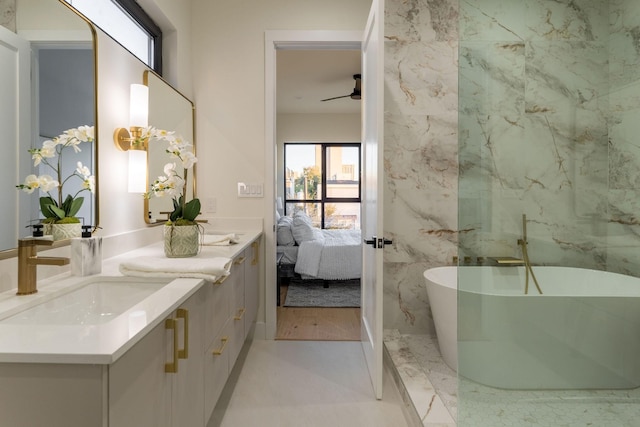 bathroom with ceiling fan, a tub to relax in, and vanity