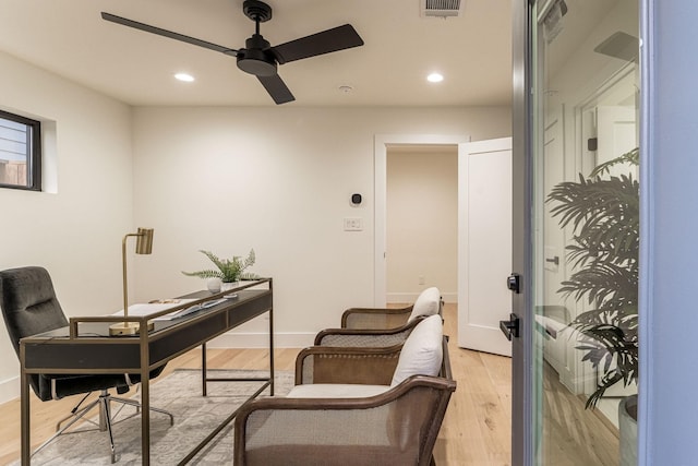 home office with light wood-type flooring and ceiling fan