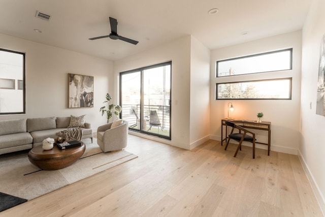 living room featuring ceiling fan and light hardwood / wood-style floors