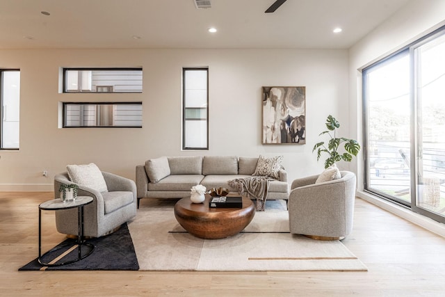 living room with ceiling fan and light hardwood / wood-style floors