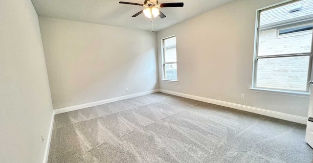 carpeted spare room featuring a healthy amount of sunlight and ceiling fan