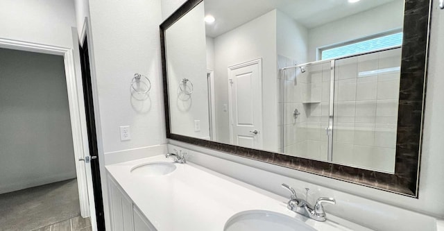 bathroom featuring a shower with door and vanity