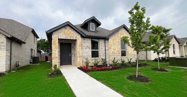 view of front of house featuring a front yard and central AC unit