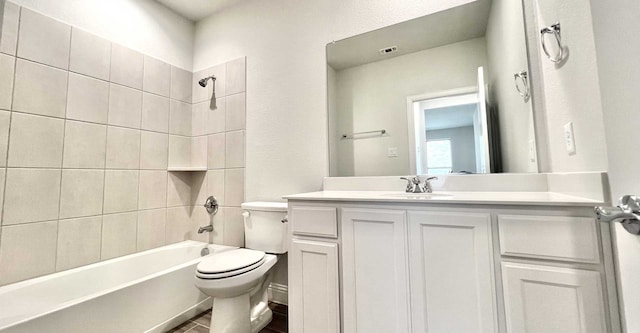 full bathroom with vanity, tiled shower / bath combo, and toilet