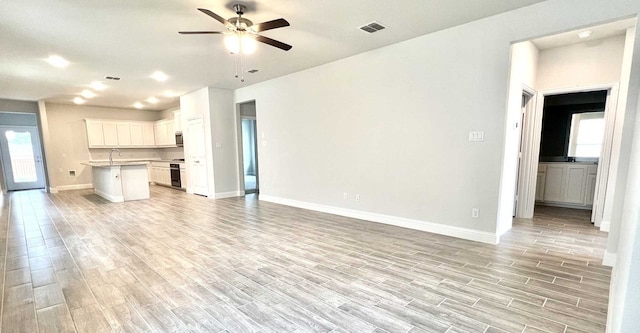 unfurnished living room with ceiling fan and sink