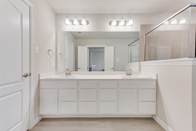 bathroom featuring walk in shower, vanity, and wood-type flooring