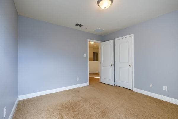 unfurnished bedroom featuring light carpet