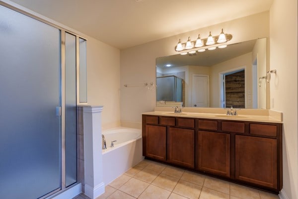 bathroom with shower with separate bathtub, vanity, and tile patterned flooring