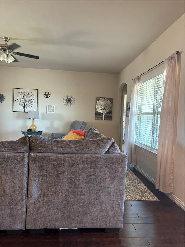 living room featuring ceiling fan and dark hardwood / wood-style floors