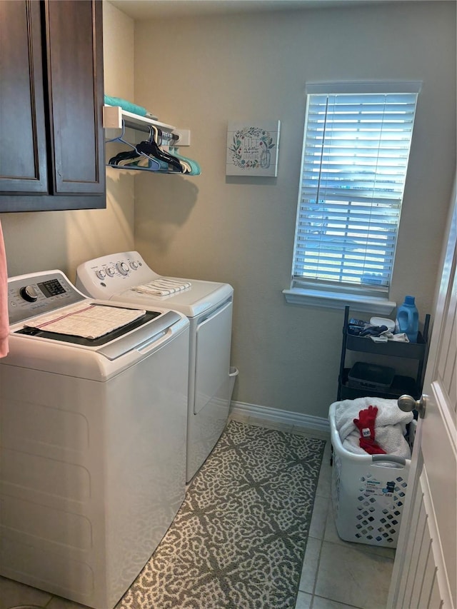 clothes washing area with cabinets, washing machine and dryer, and light tile patterned flooring