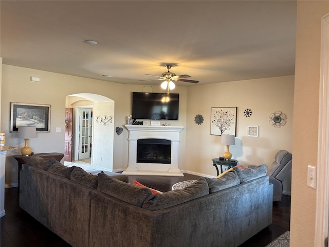 living room featuring ceiling fan and dark hardwood / wood-style floors