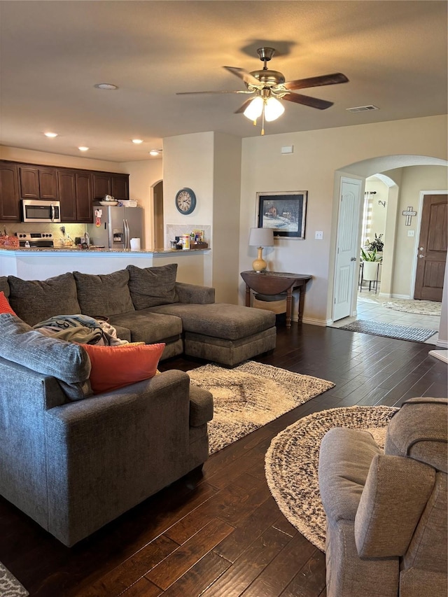 living room featuring dark wood-type flooring and ceiling fan