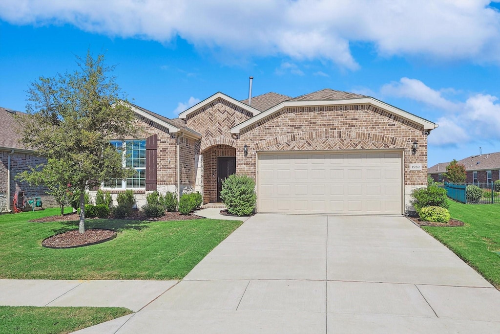 view of front of house featuring a front yard and a garage