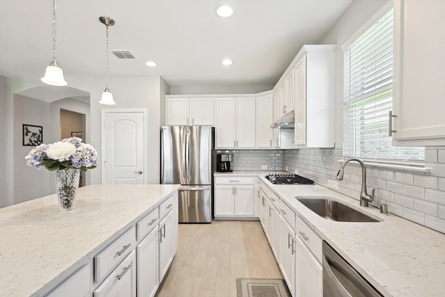 kitchen with stainless steel appliances, white cabinets, and sink