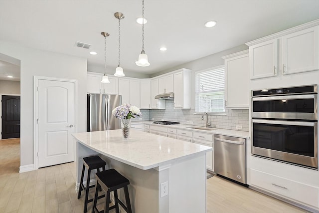 kitchen featuring a kitchen island, white cabinets, and appliances with stainless steel finishes